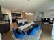 Open concept dining area with modern light fixture and blue chairs at 120 Panda Way, Davenport, FL 33837