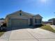 Light green house with a two-car garage and a paved driveway at 120 Panda Way, Davenport, FL 33837