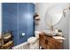 Stylish powder room with blue wallcovering, patterned floor, and a unique sink at 12549 Encore At Ovation Way, Winter Garden, FL 34787