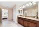 Double vanity bathroom with granite countertops and a walk-in shower at 1455 Rolling Fairway Dr, Davenport, FL 33896