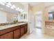 Double vanity bathroom with granite countertops, and access to a private patio at 1455 Rolling Fairway Dr, Davenport, FL 33896