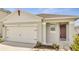 House exterior featuring a two-car garage and front door at 1516 Quinta Rd, Kissimmee, FL 34744