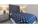 Bedroom with a blue and white patterned bedding, and two nightstands at 1560 Flange Dr, Davenport, FL 33896