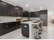 Modern kitchen with dark cabinets, an island, and stainless steel appliances at 1560 Flange Dr, Davenport, FL 33896