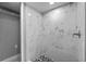 A tiled shower stall featuring marble-look wall tiles and unique black and white floor tiles at 1900 E Orange Ave, Eustis, FL 32726