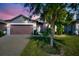 Inviting home exterior featuring a brown garage door and landscaped yard at 217 Montoro Ln, Davenport, FL 33837