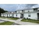 Row of townhouses with gray and white exteriors, and small yards at 2614 Old Kent Cir, Kissimmee, FL 34758