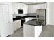 Modern kitchen with white cabinets, black countertops, and stainless steel appliances at 2614 Old Kent Cir, Kissimmee, FL 34758