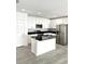 Modern kitchen with white cabinets, black countertops, and stainless steel appliances at 2614 Old Kent Cir, Kissimmee, FL 34758