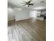 Open living room with wood-look flooring, a ceiling fan and access to kitchen at 2614 Old Kent Cir, Kissimmee, FL 34758