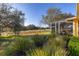 Expansive backyard featuring lush landscaping and a screened-in patio overlooking the green golf course at 26622 Bull Run, Leesburg, FL 34748