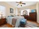 Comfortable bedroom with a queen-size bed, wood floors, ceiling fan, and warm natural light at 26622 Bull Run, Leesburg, FL 34748