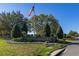 The Arlington Ridge community entrance features manicured landscaping, a brick sign, and an American flag, creating an inviting welcome at 26622 Bull Run, Leesburg, FL 34748