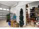 Cluttered garage interior with visible tools, storage bins, and a partially open garage door at 26622 Bull Run, Leesburg, FL 34748