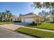 Exterior view showcasing a well-kept lawn, tasteful landscaping, and a spacious three-car garage with ample parking at 26622 Bull Run, Leesburg, FL 34748