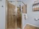 Well-maintained shower enclosure with glass doors, tiled walls, and convenient storage shelves at 26622 Bull Run, Leesburg, FL 34748