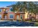 Front view of two-story townhome with orange exterior and landscaping at 2713 Roadster Ln, Kissimmee, FL 34746