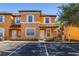 Two-story townhome with orange exterior, white trim, and landscaping at 2713 Roadster Ln, Kissimmee, FL 34746