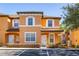 Attractive two-story townhome with orange exterior, white trim, and landscaping at 2713 Roadster Ln, Kissimmee, FL 34746