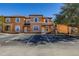 Two-story townhome with orange exterior, white trim, and parking at 2713 Roadster Ln, Kissimmee, FL 34746