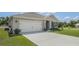 Tan house with a two-car garage and nicely manicured lawn at 362 Alexzander Way, Winter Haven, FL 33881