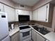 Updated kitchen featuring modern white cabinets and appliances with sink and microwave at 3984 Atrium Dr # 4, Orlando, FL 32822