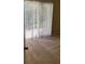 Bedroom with tan carpet and sliding glass doors to balcony at 4372 Paradise Cove Ct, Kissimmee, FL 34746