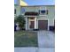 Two-story townhome with a green exterior, brown garage door, and small front yard at 4372 Paradise Cove Ct, Kissimmee, FL 34746