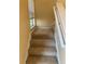 Beige carpeted staircase with a simple white railing at 4372 Paradise Cove Ct, Kissimmee, FL 34746