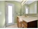 Bathroom with wood vanity, large mirror, and exterior access at 4612 Osceola Point Trl, Kissimmee, FL 34746