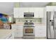 Stainless steel appliances and white cabinetry in this kitchen at 4612 Osceola Point Trl, Kissimmee, FL 34746