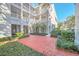 Brick walkway leads to a 3-story building with balconies and lush landscaping at 651 Celebration Ave # 651, Celebration, FL 34747