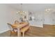 Bright dining area with light wood table and bench, chandelier, and hardwood floors at 651 Celebration Ave # 651, Celebration, FL 34747
