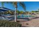 Community pool with lounge chairs and umbrellas at 7136 Red Lantern Dr # 7136, Harmony, FL 34773