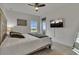 A well-lit bedroom has soft bedding, a ceiling fan, a TV, and a window with an expansive view at 820 Windlass Ct, Kissimmee, FL 34746
