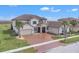 Two-story house with brown tile roof and a three-car garage, overlooking the water at 820 Windlass Ct, Kissimmee, FL 34746