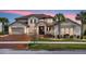 Two-story house with brown tile roof, stone accents, and a three-car garage at 820 Windlass Ct, Kissimmee, FL 34746