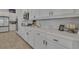 Modern kitchen featuring stone countertops, white cabinetry with gold handles, and stainless steel appliances at 820 Windlass Ct, Kissimmee, FL 34746