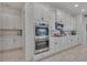 Modern kitchen featuring stainless steel appliances, white cabinetry with gold handles, and stone countertops at 820 Windlass Ct, Kissimmee, FL 34746