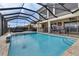 This in-ground pool is surrounded by a screen enclosure, an iron fence, and an outdoor seating area at 820 Windlass Ct, Kissimmee, FL 34746
