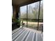 Screened porch with wooded views and striped rug at 1375 Tuscana Ln # 1106, Davenport, FL 33896