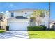 Two-story house with a white garage door and manicured lawn at 1003 Lake Berkley Dr, Kissimmee, FL 34746