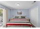 Bright bedroom with a striped bedspread and private balcony at 1017 Park Ridge Cir, Kissimmee, FL 34746