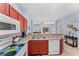 Open concept kitchen with breakfast bar, stainless steel appliances and view to living room at 1017 Park Ridge Cir, Kissimmee, FL 34746