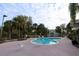 Community swimming pool with lounge chairs and tropical palm trees at 14764 Laguna Beach Cir, Orlando, FL 32824