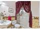 Bathroom with a shower, toilet and sink. Features decorative wallpaper and curtains at 1515 Sunset Pointe Pl, Kissimmee, FL 34744
