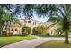 Two-story house with tile roof, manicured lawn, and circular driveway at 1515 Sunset Pointe Pl, Kissimmee, FL 34744