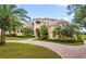 Impressive two-story home with palm trees and a brick driveway at 1515 Sunset Pointe Pl, Kissimmee, FL 34744