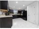 Modern kitchen with dark cabinetry and tile floor at 1606 Steely Dr, Dundee, FL 33838