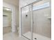 Walk-in shower featuring glass doors, bright tile, and a built-in toiletry shelf at 1607 Kona Ln, Davenport, FL 33897